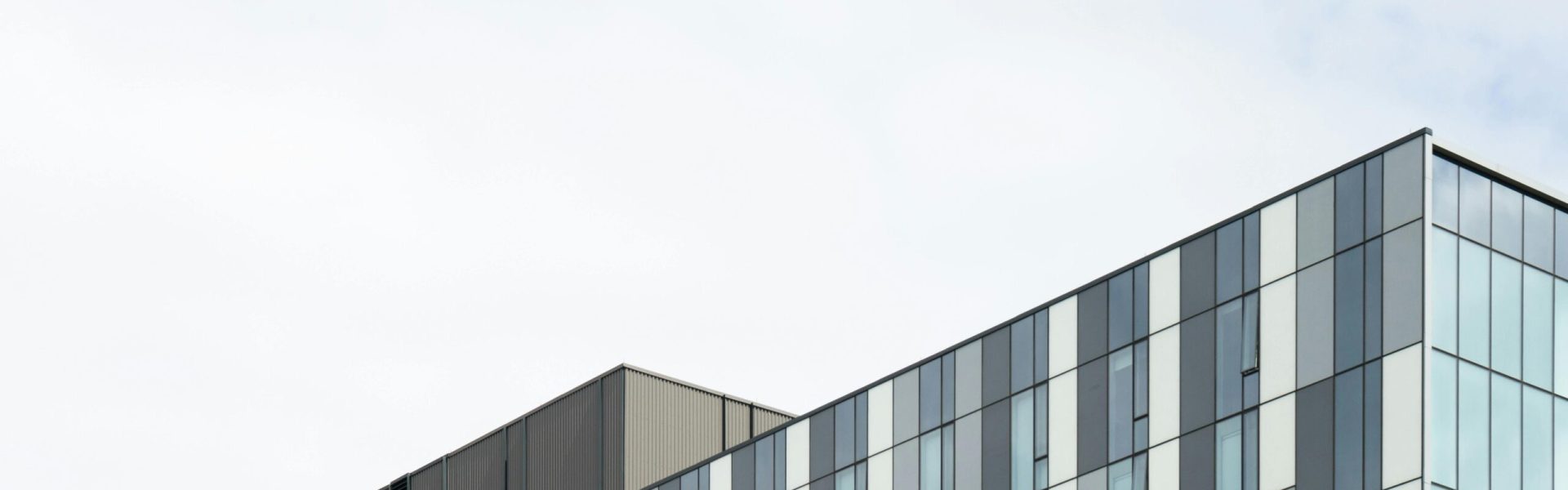 Contemporary glass office building exterior showcasing geometric patterns and modern architecture.